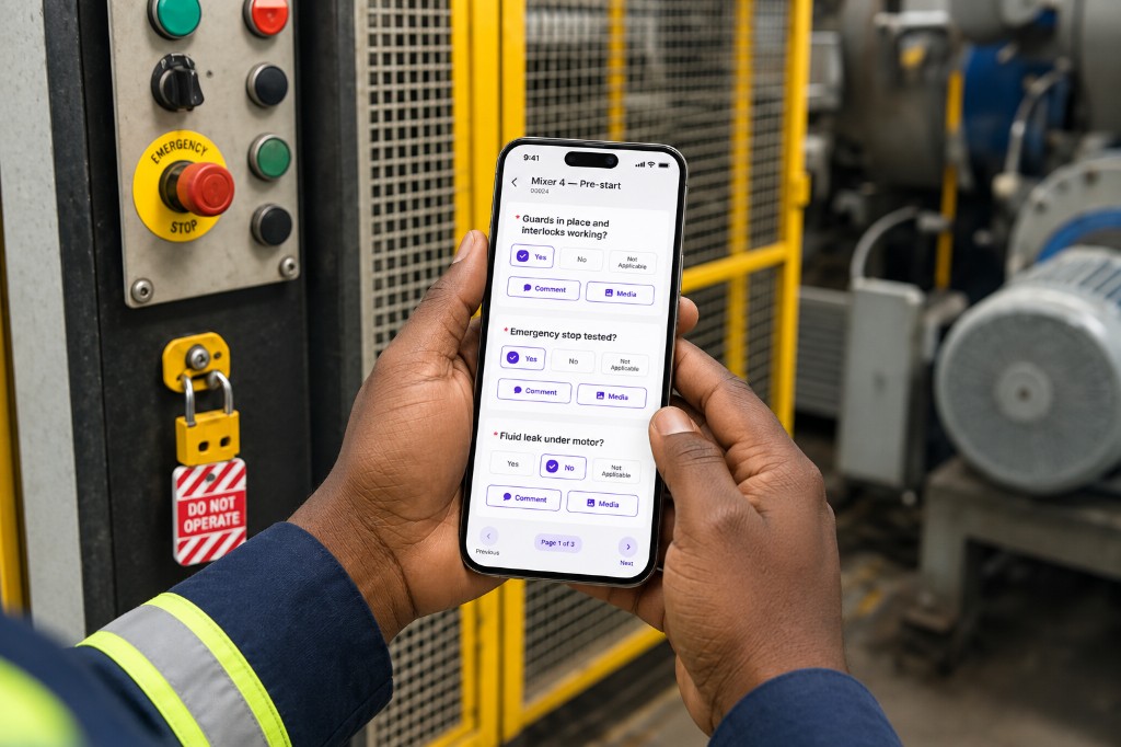 Operator completing a Mixer 4 pre-start check on a phone beside the emergency stop and a lockout tag